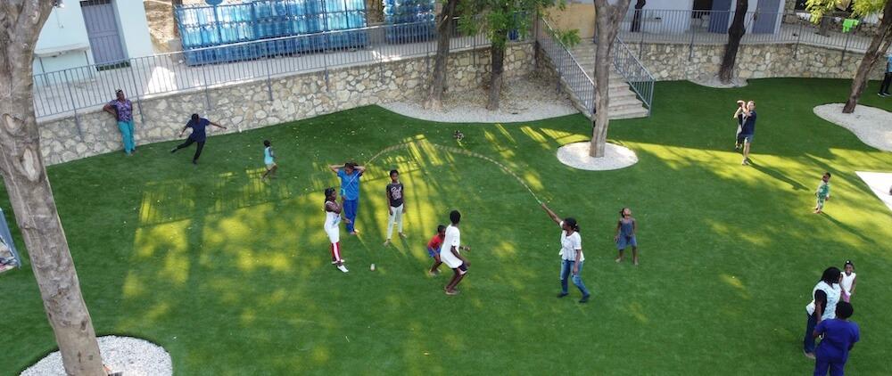 Children playing on synthetic lawn at Have Faith Haiti